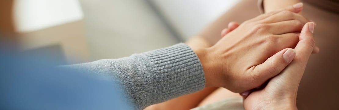 Close-up view of people holding hands.
