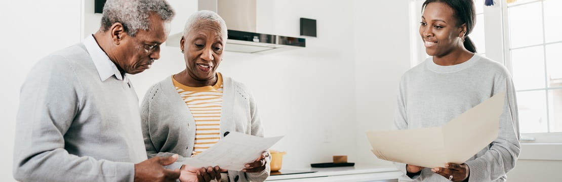Insurance broker and senior couple at home with folders.